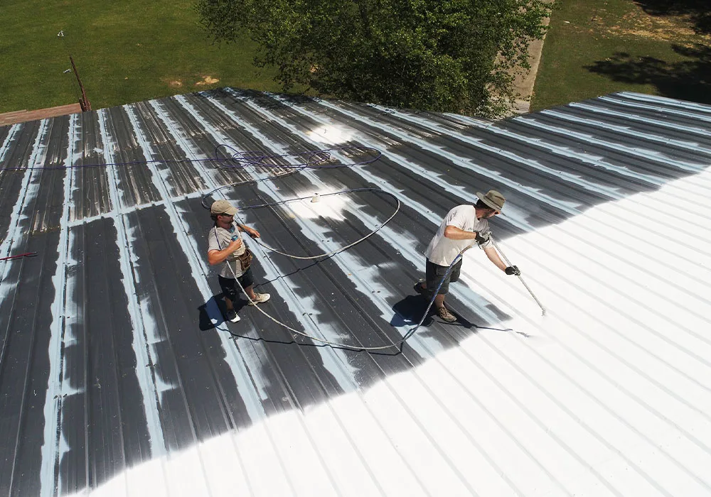 Crew applying reflective roof coating