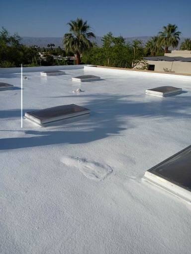 Wide view of a finished reflective flat roof with skylights