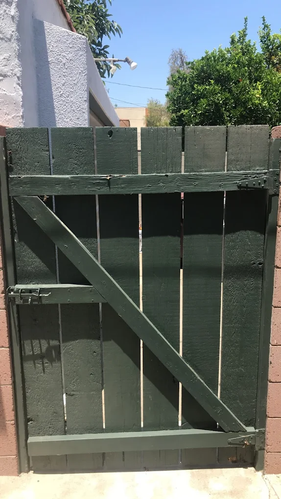 Wrought-iron gate freshly refinished in deep forest green
