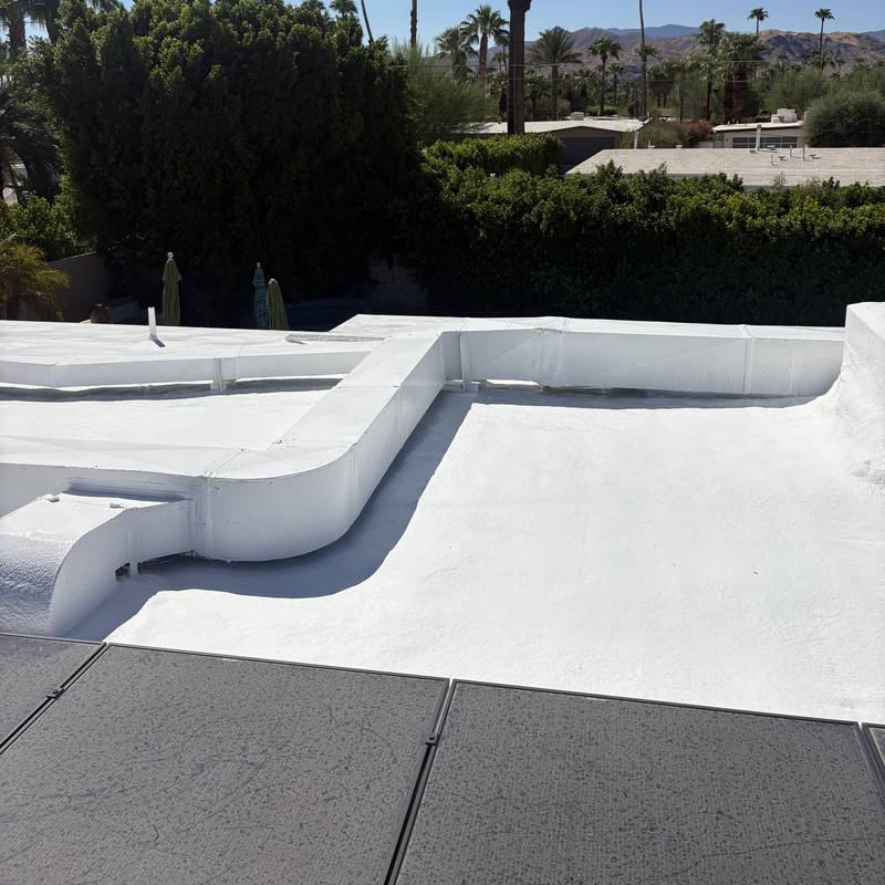 Ductwork sealed in: Rooftop ducts wrapped into the same seamless white coating as the roof.