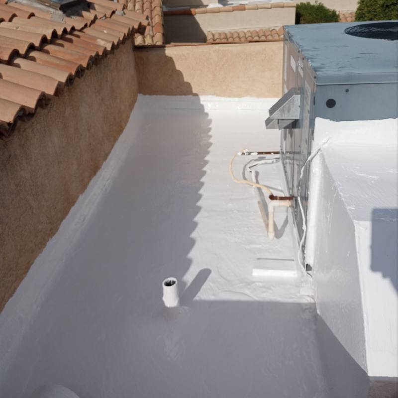 Tight spaces, fully sealed: A narrow roof deck between stucco walls and an AC unit, coated white.