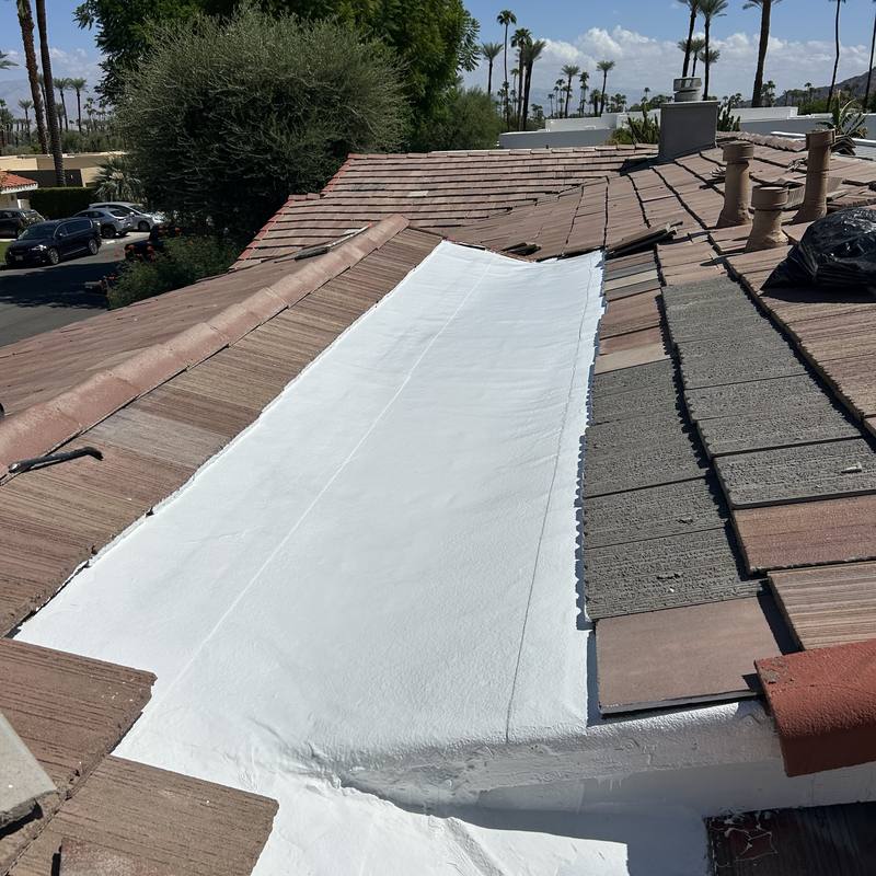 Tile valley relined: Tile pulled back and a new white membrane run down the valley.