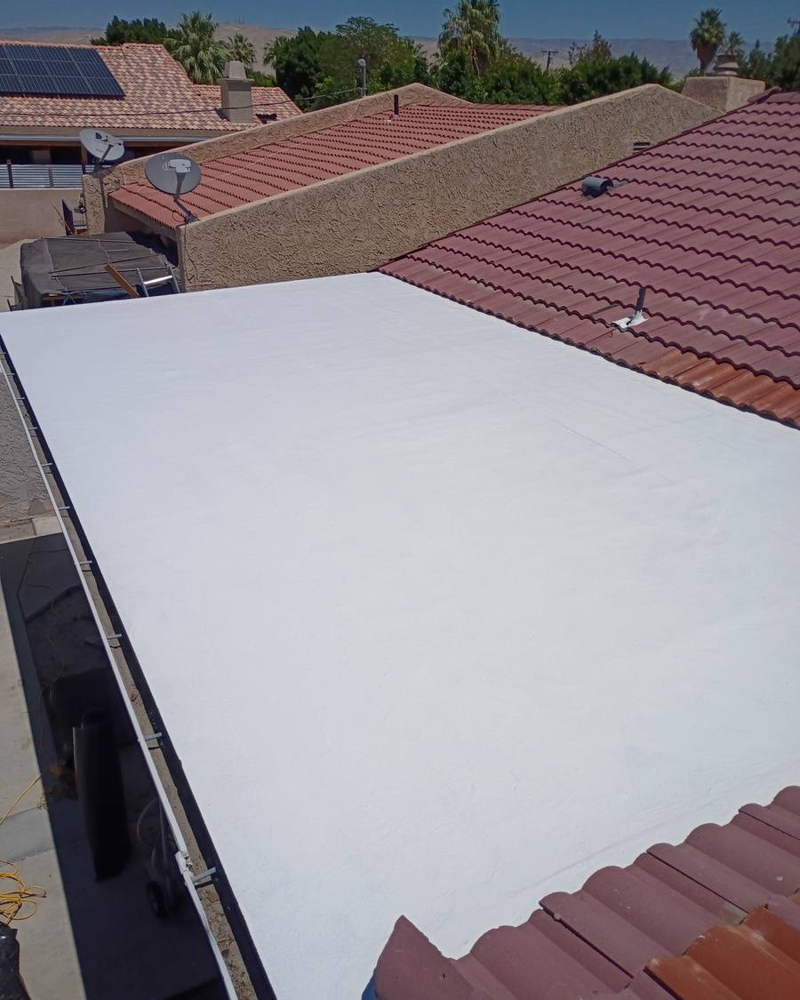 Finished white flat section between red tile roofs