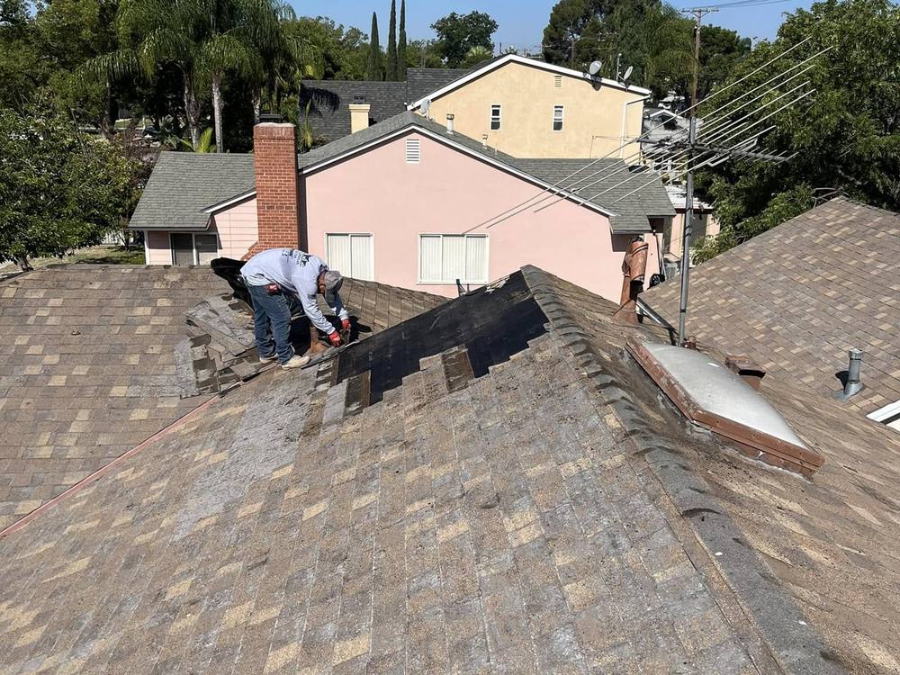Roofer installing asphalt shingles on a residential roof